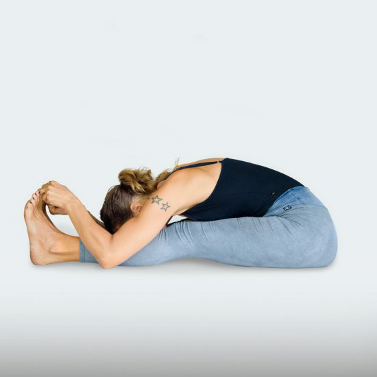 demonstration of Seated forward bend or Paschimottanasana in sanskrit